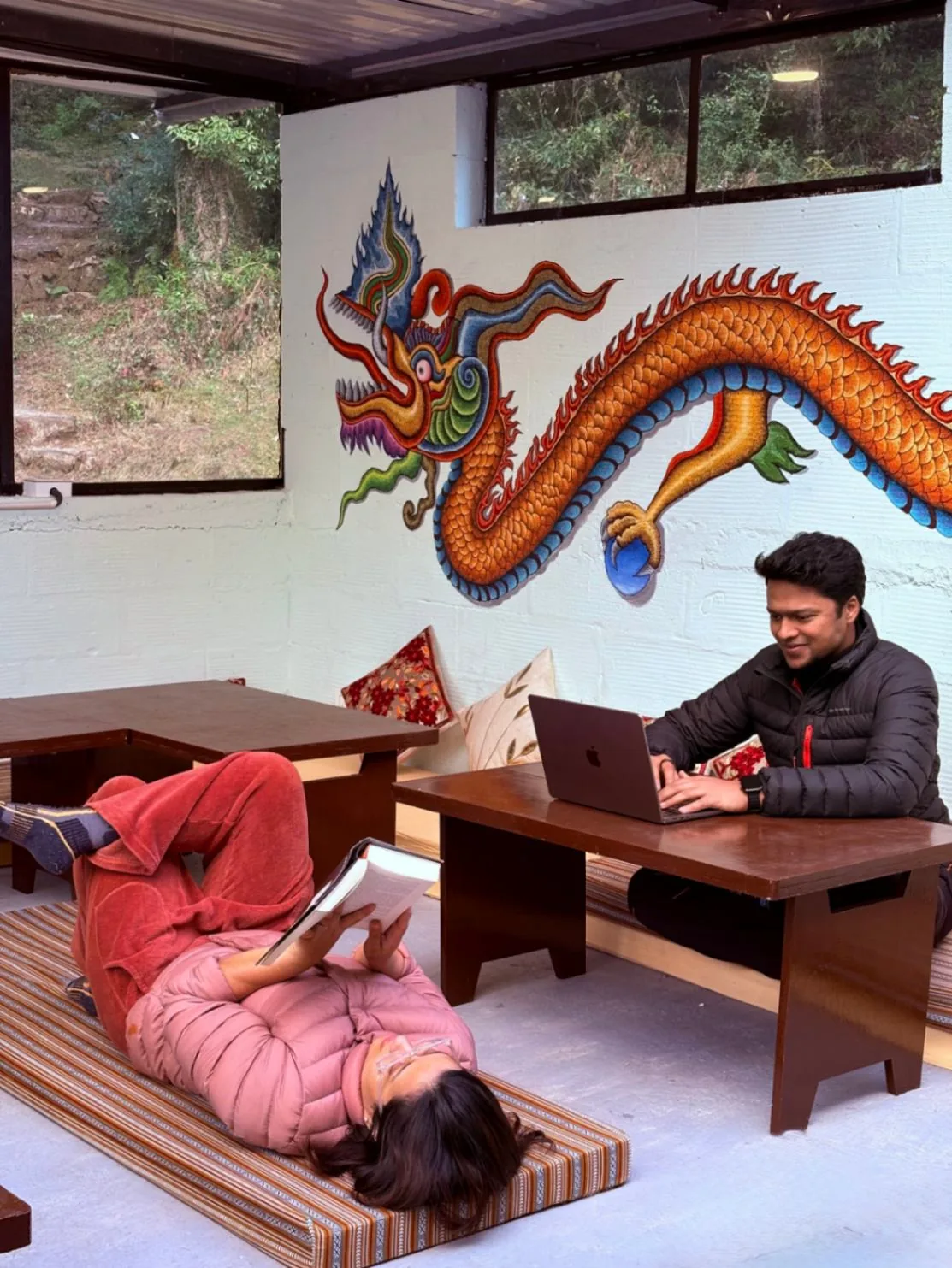 A guest working on a laptop at the low table in the common room
