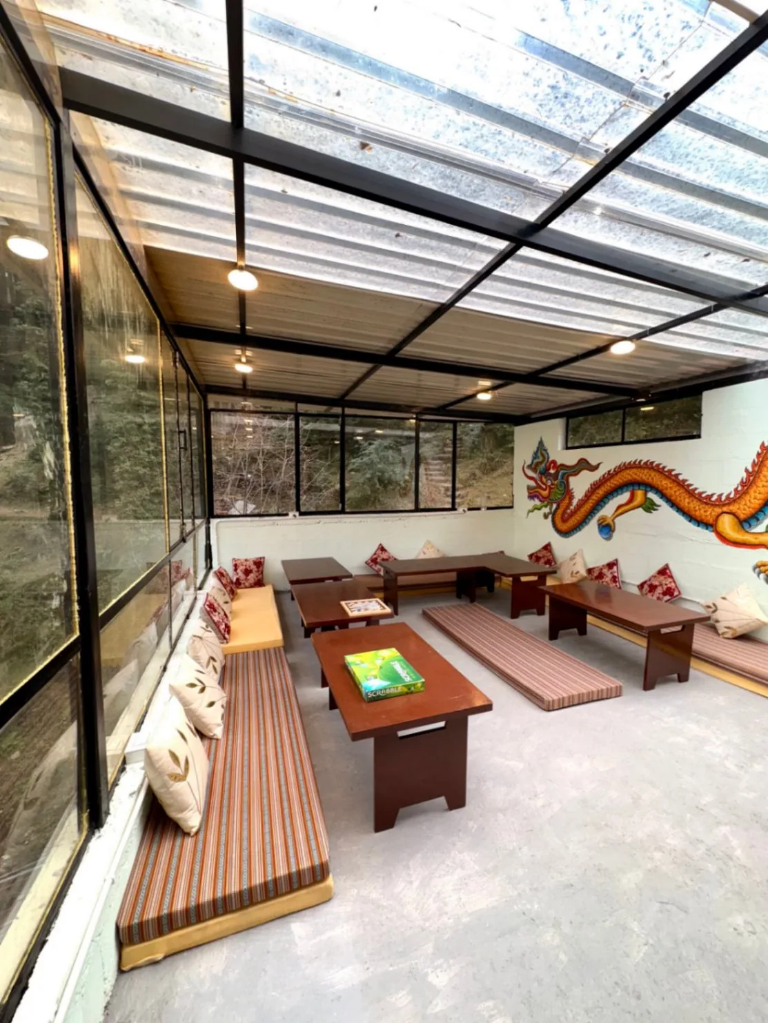 The glass-roofed common room with low tables and floor seating