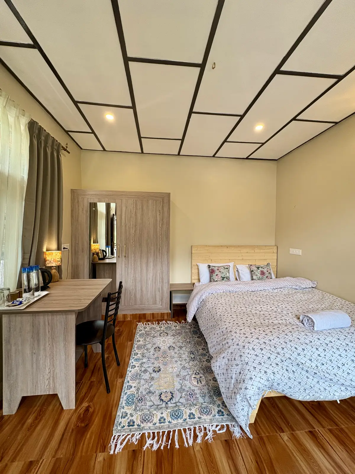 An Evolve Home deluxe queen room with a mirrored wardrobe and a desk with a tea tray