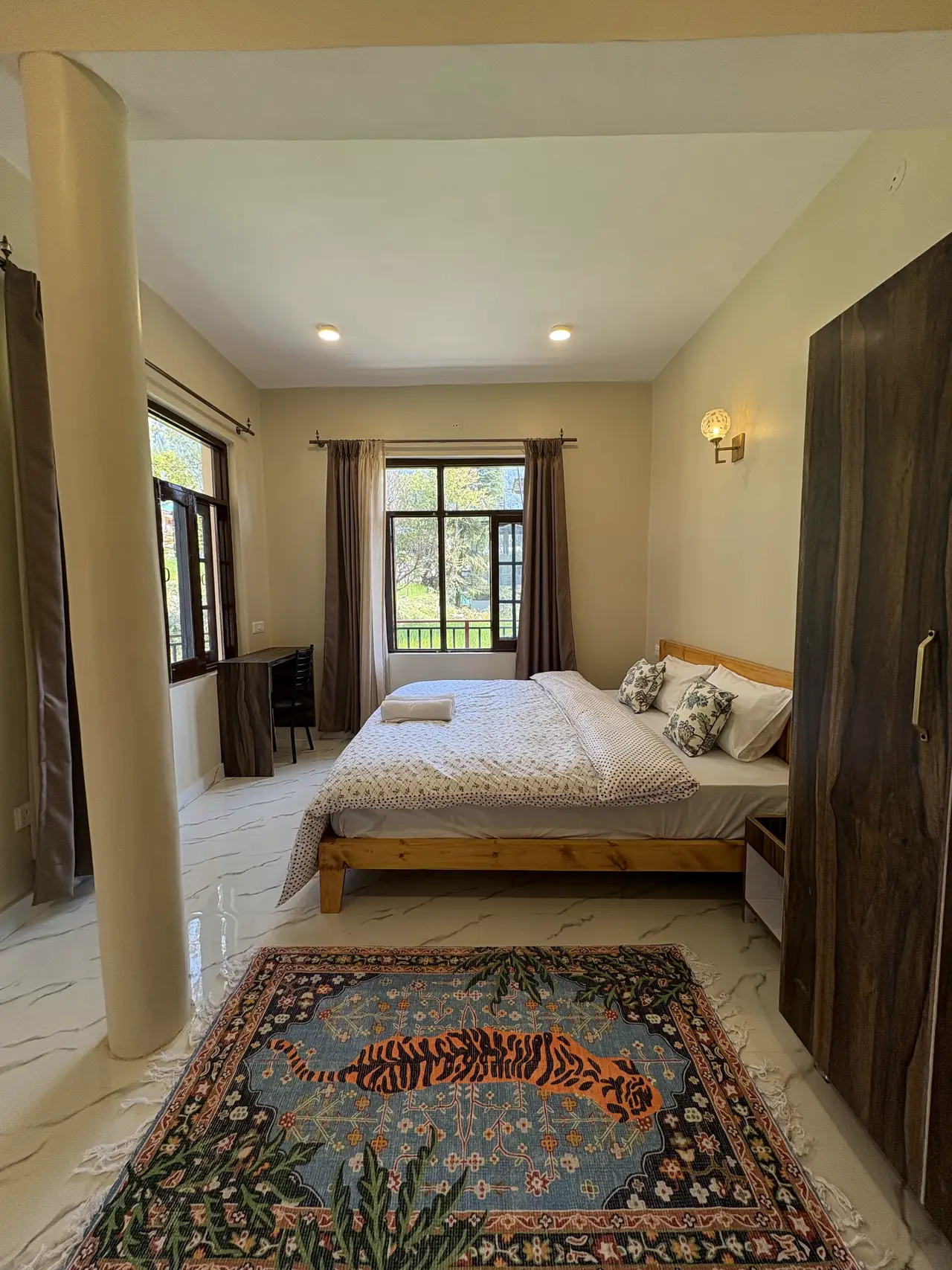 The full width of the superior king room, desk by the window and rug across the floor