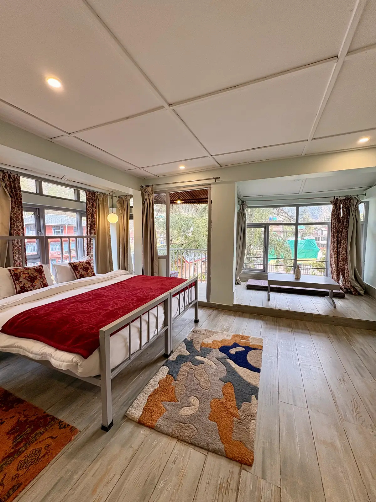 The studio apartment with its bed, two rugs, balcony door and a window seat